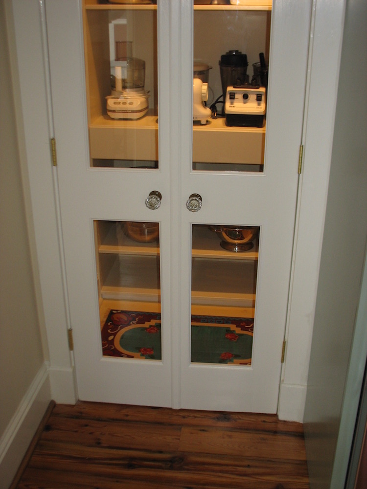 New pantry doors with clear glass panels showing the hand painted rug on the other side